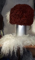 Röd mössa av fårskinn och vit halsduk av vitt fårskinn